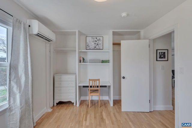 interior space featuring two closets, an AC wall unit, and light wood-type flooring