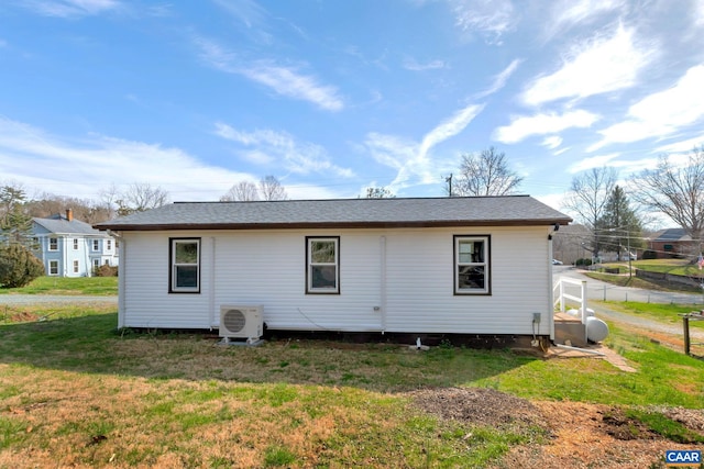 rear view of property featuring a yard and ac unit