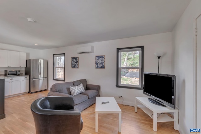 living room featuring light wood-type flooring and a wall unit AC