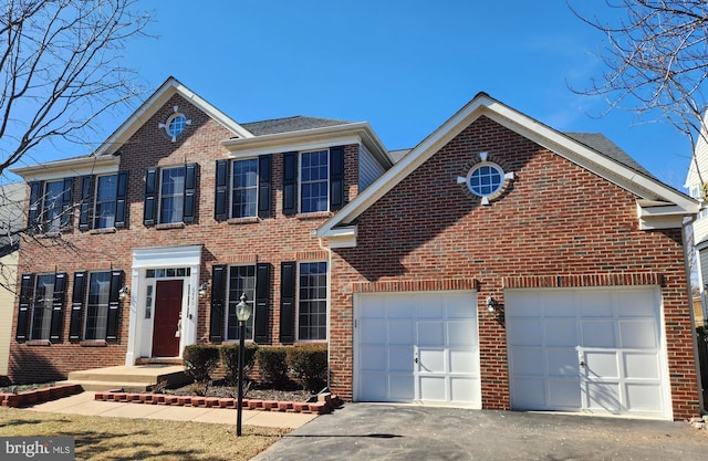 view of front facade with a garage, driveway, and brick siding