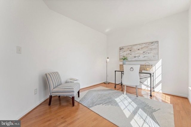 living area featuring baseboards and wood finished floors