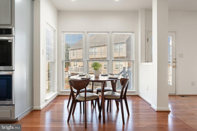 dining area featuring wood-type flooring, visible vents, and baseboards