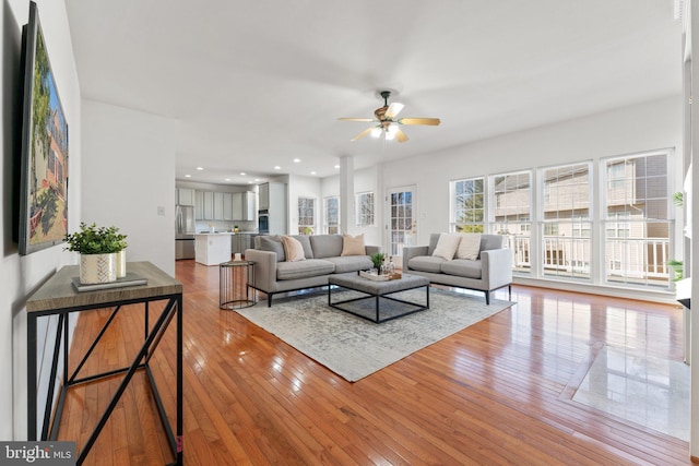 living area with ceiling fan, wood-type flooring, and recessed lighting