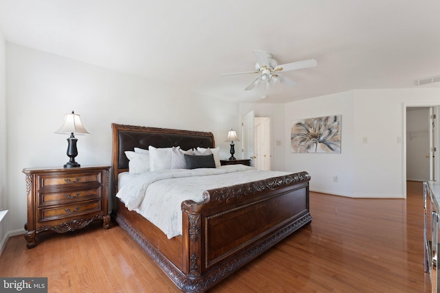 bedroom featuring light wood-style floors, baseboards, visible vents, and ceiling fan