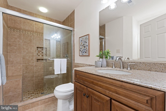 full bathroom featuring a stall shower, visible vents, vanity, and toilet