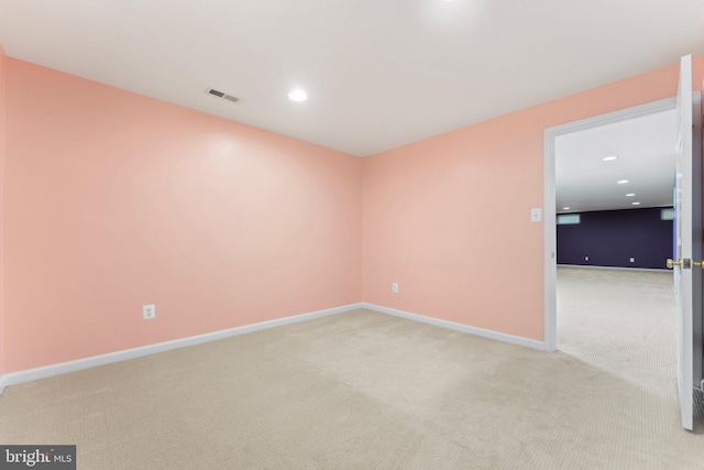 spare room with recessed lighting, light carpet, visible vents, and baseboards