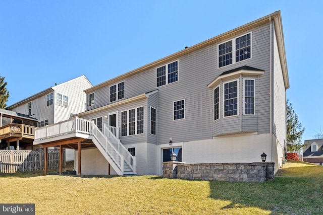 back of house featuring a lawn, fence, a wooden deck, and stairs