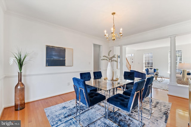 dining space featuring ornate columns, baseboards, ornamental molding, and hardwood / wood-style floors