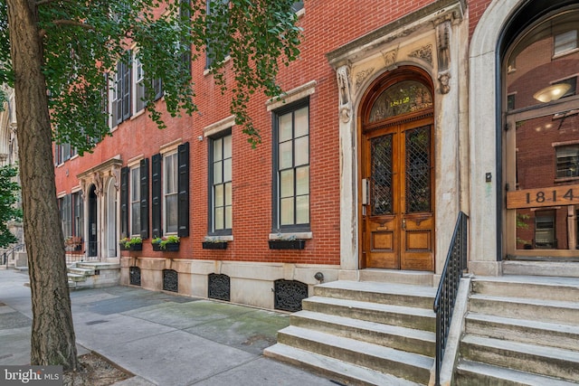 doorway to property featuring brick siding