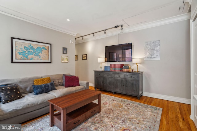 living area with recessed lighting, wood finished floors, baseboards, ornamental molding, and rail lighting