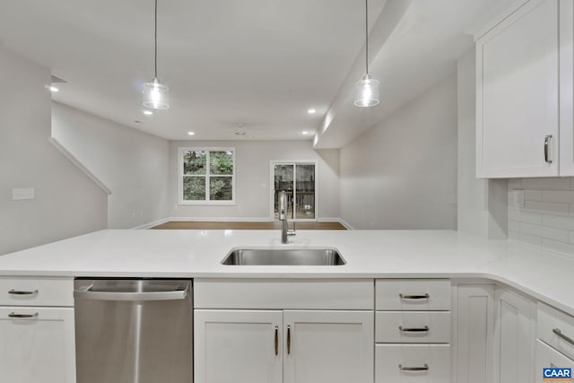 kitchen with white cabinetry, sink, stainless steel dishwasher, and decorative light fixtures