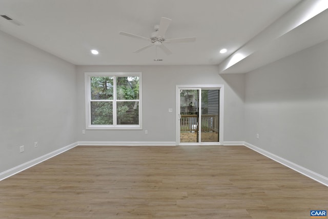 empty room with ceiling fan and light hardwood / wood-style flooring