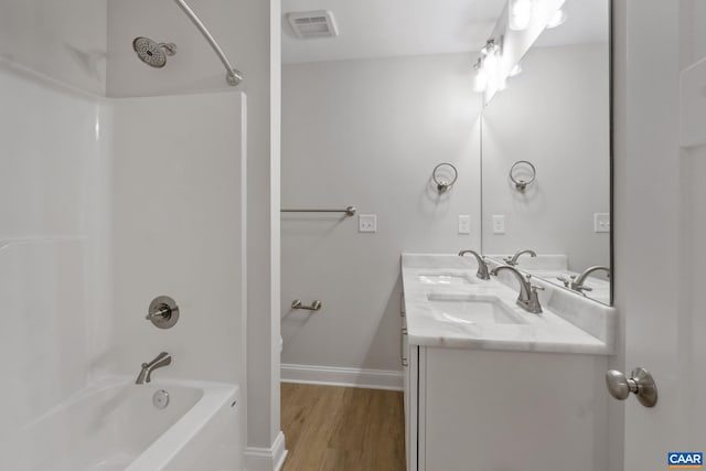 bathroom featuring vanity, hardwood / wood-style floors, and  shower combination