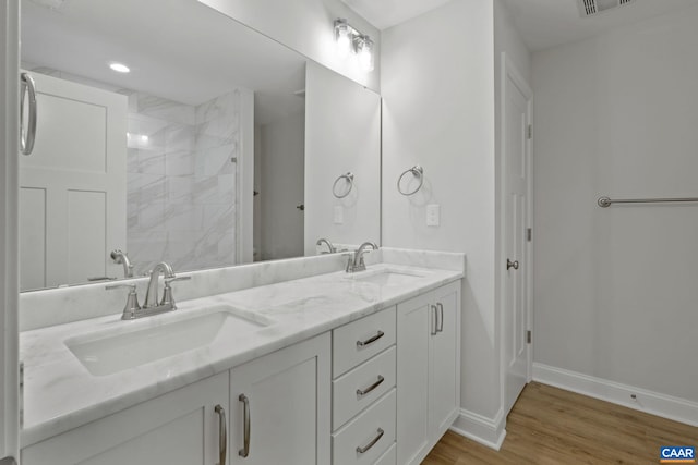 bathroom with vanity, hardwood / wood-style floors, and a tile shower