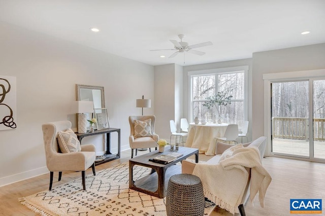 living area with light hardwood / wood-style flooring and ceiling fan