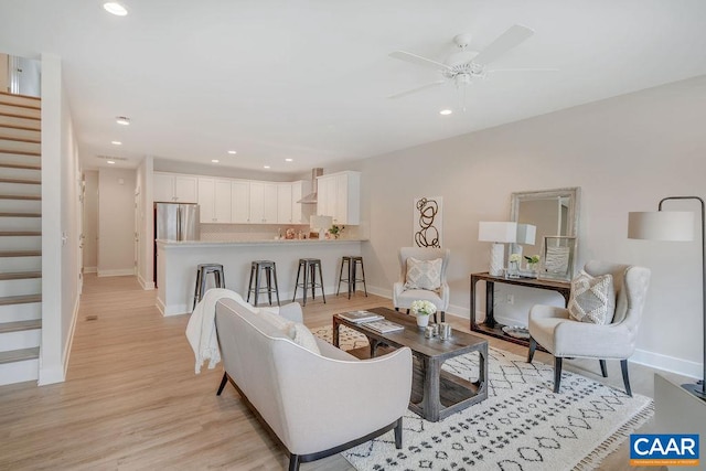 living room featuring light hardwood / wood-style flooring and ceiling fan