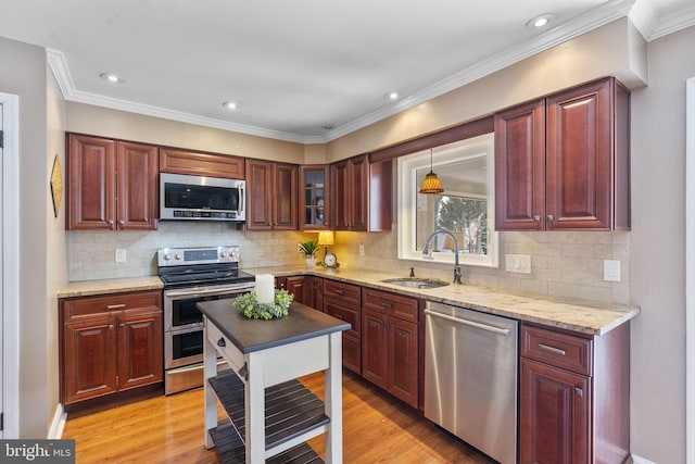 kitchen featuring light wood-style flooring, a sink, light stone counters, tasteful backsplash, and appliances with stainless steel finishes