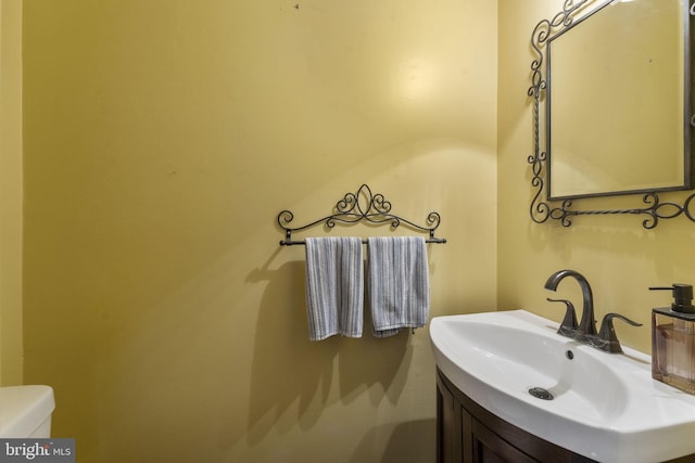 half bathroom featuring toilet and vanity