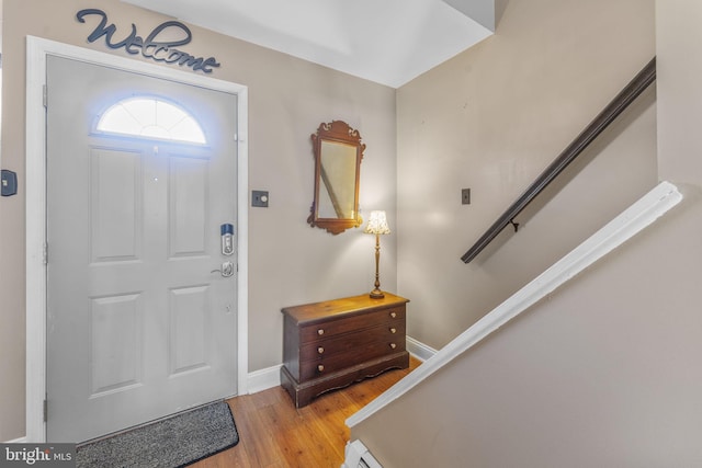 entrance foyer featuring stairway, light wood-style flooring, and baseboards