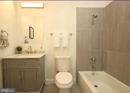 3324 N Market St, Wilmington, DE 19802 - bathroom with toilet, vanity, shower / tub combination, a wall unit AC, and baseboards