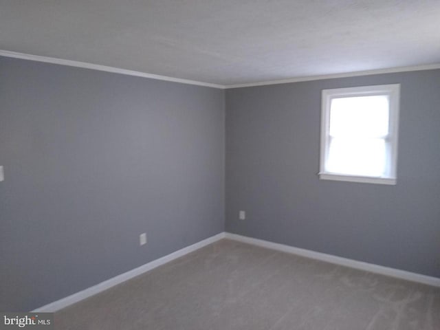 carpeted spare room with baseboards and crown molding