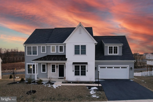 modern inspired farmhouse featuring driveway, a garage, a shingled roof, metal roof, and a standing seam roof