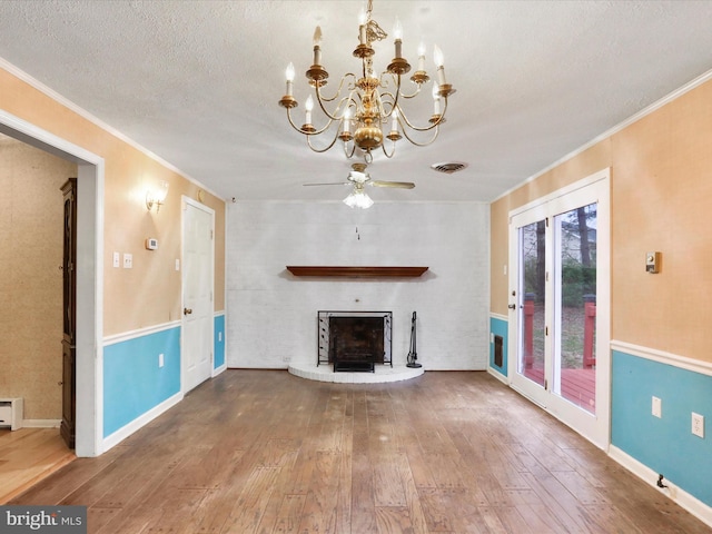 374 Tuscawilla Dr, Charles Town, WV 25414 - unfurnished living room featuring a fireplace, hardwood / wood-style flooring, crown molding, and ceiling fan with notable chandelier