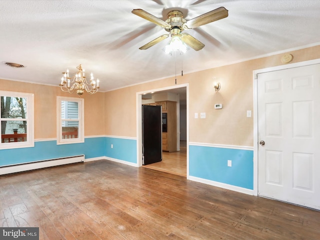 374 Tuscawilla Dr, Charles Town, WV 25414 - spare room featuring visible vents, baseboard heating, crown molding, ceiling fan with notable chandelier, and wood-type flooring