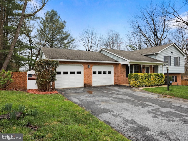374 Tuscawilla Dr, Charles Town, WV 25414 - split level home with a front yard, a shingled roof, an attached garage, brick siding, and driveway