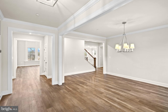 unfurnished dining area featuring a chandelier, dark wood-type flooring, ornamental molding, and stairs