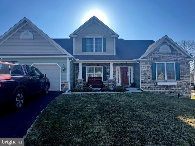 view of front facade with a garage, stone siding, a front lawn, and driveway