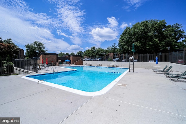 community pool featuring fence and a patio