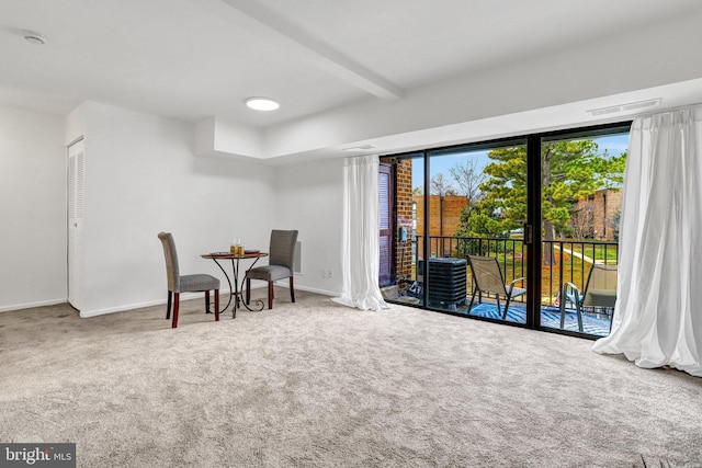 sitting room with beamed ceiling, carpet, visible vents, and baseboards