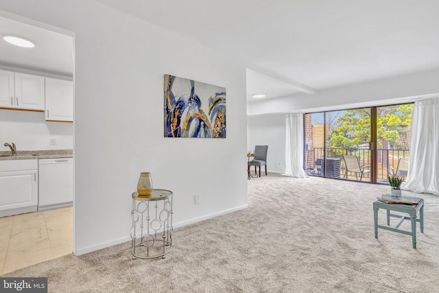 living area featuring light carpet and baseboards