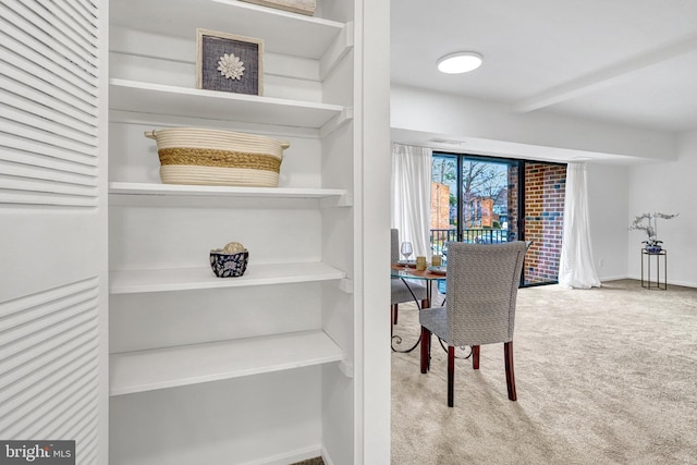 dining room featuring carpet flooring, beamed ceiling, visible vents, and baseboards