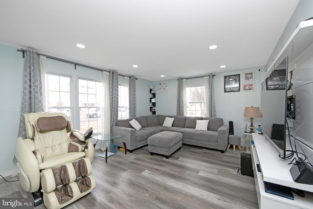 living room with light wood-style flooring and recessed lighting