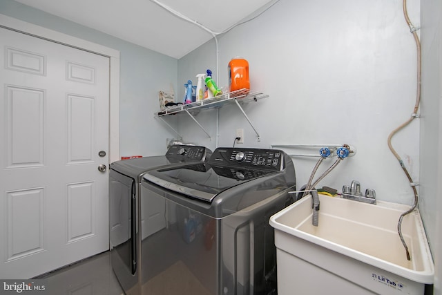 clothes washing area featuring washer and dryer, laundry area, and a sink