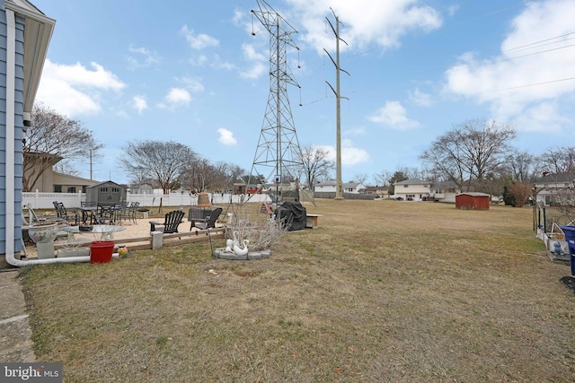 view of yard with a patio area, a residential view, fence, and a storage unit