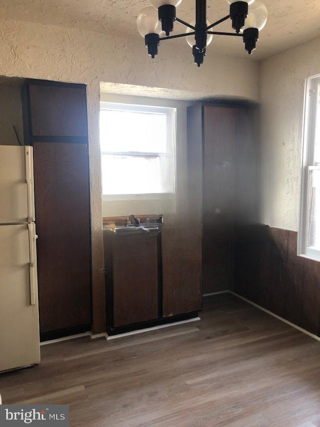 kitchen with white fridge, a chandelier, and wood-type flooring