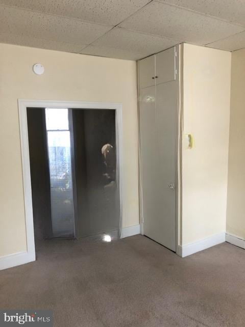 unfurnished room with a drop ceiling and carpet flooring