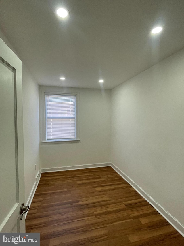 unfurnished room featuring recessed lighting, dark wood-type flooring, and baseboards