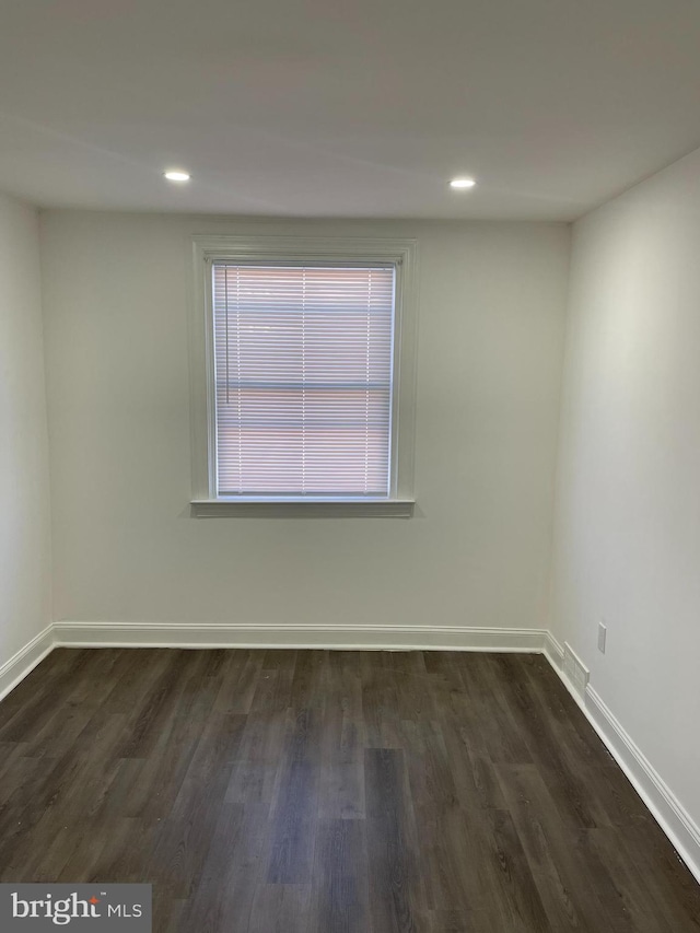 spare room featuring dark wood finished floors, baseboards, and recessed lighting