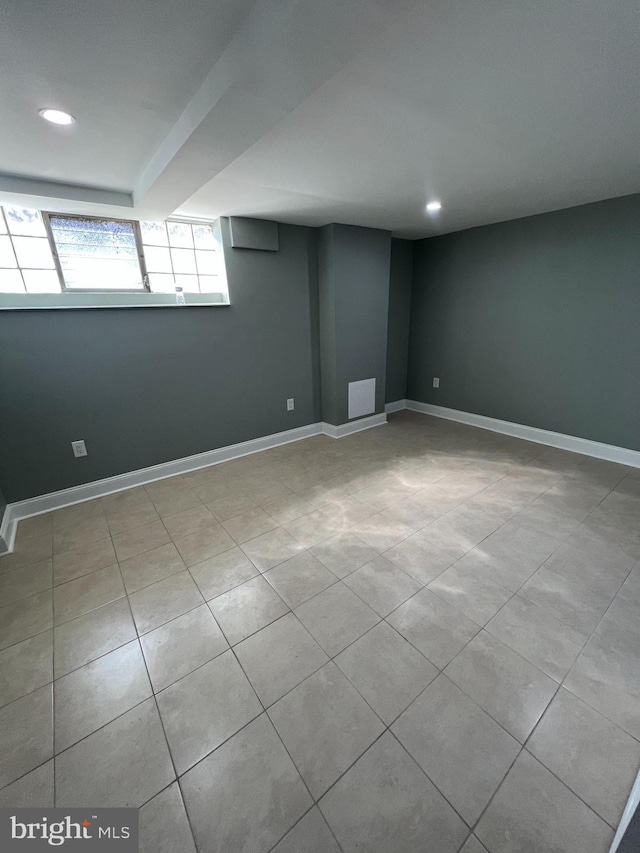 basement with baseboards, recessed lighting, and visible vents