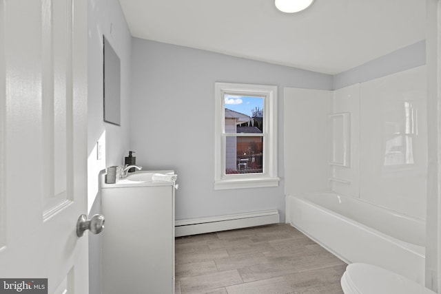 full bathroom featuring toilet, wood-type flooring, tub / shower combination, a baseboard radiator, and vanity