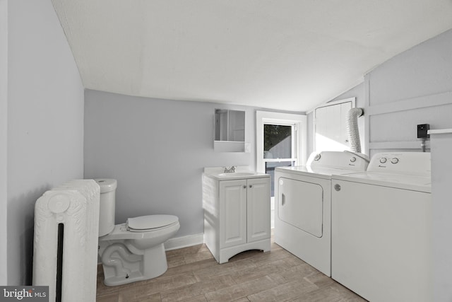 interior space featuring sink, radiator, washing machine and dryer, and light hardwood / wood-style floors