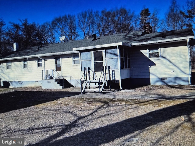 view of front facade with a shingled roof, crawl space, and a chimney