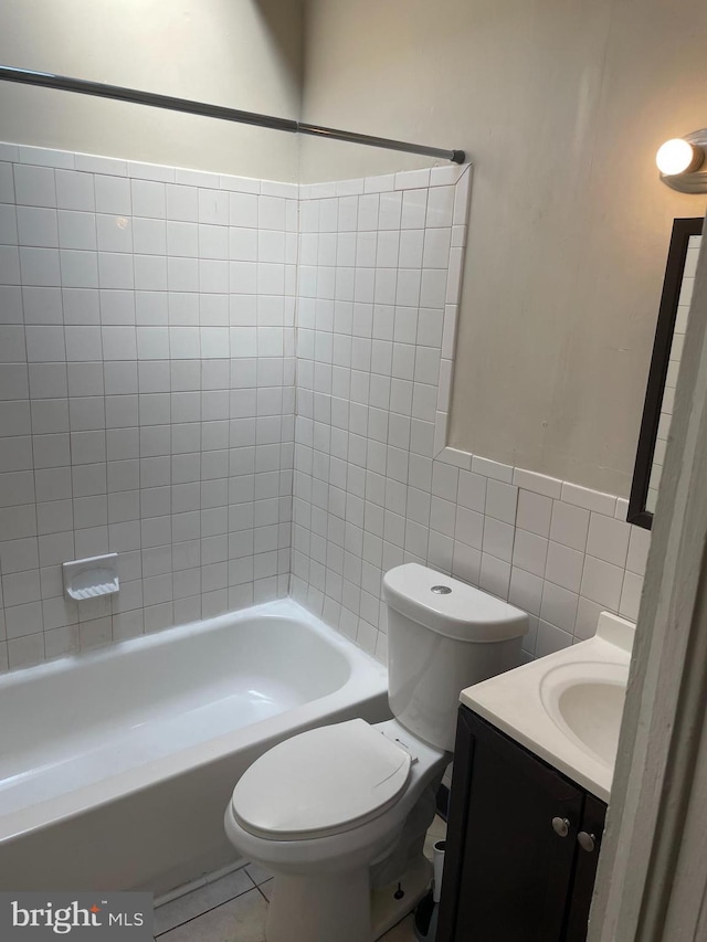 bathroom featuring tile patterned flooring, tile walls, toilet, and vanity