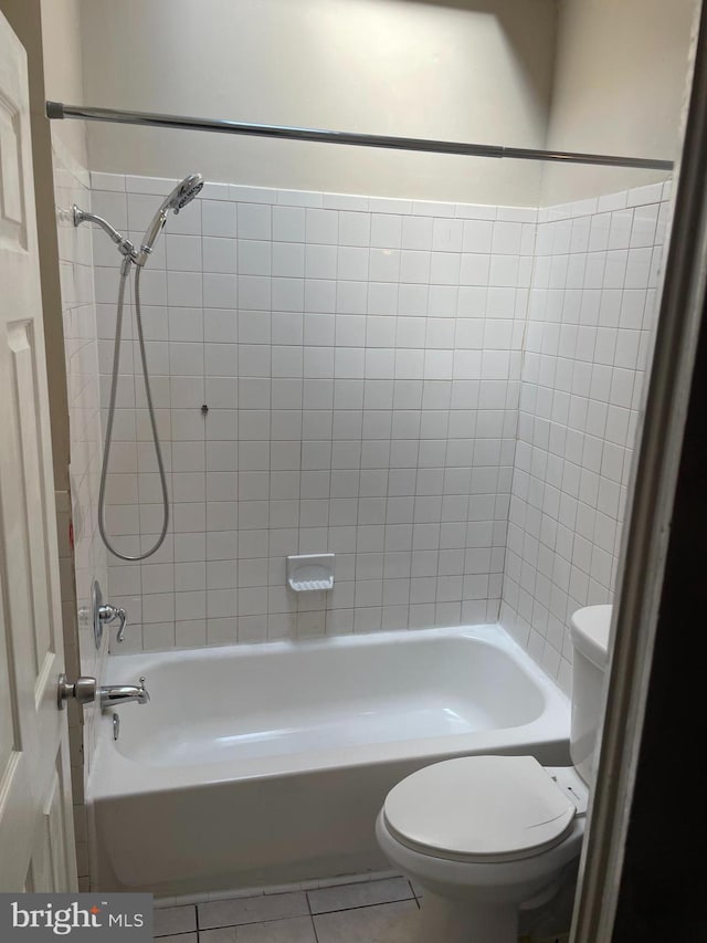 bathroom featuring tile patterned flooring, shower / bathing tub combination, and toilet