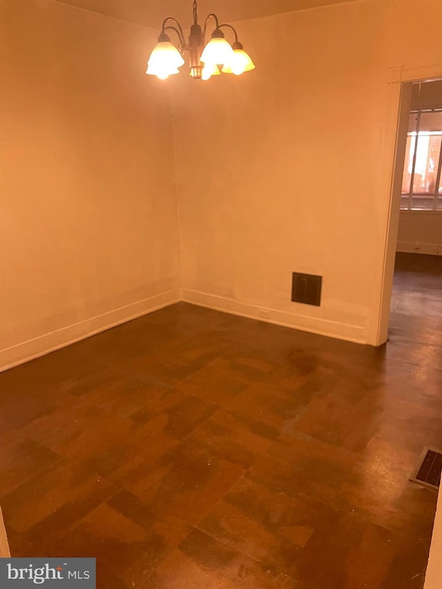 empty room featuring visible vents, baseboards, and an inviting chandelier