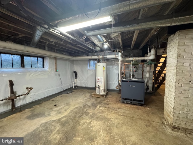 below grade area featuring gas water heater, a heating unit, and plenty of natural light